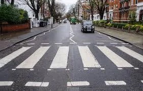 Zebra crossing with white stripes across a quiet road, a safe place for children to cross with an adult