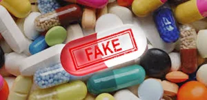 Heap of colourful pills and capsules with one large red and white capsule stamped FAKE, showing that fake drugs look real