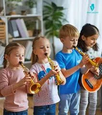 Four young children playing small gold wind instruments, while one child holds an orange guitar