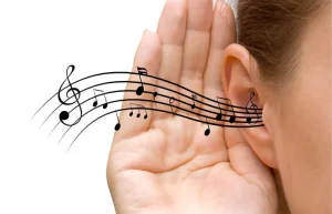 A hand cupped behind an ear with a line of music staff and notes flowing towards it, showing careful listening